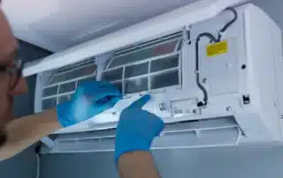 HVAC technician inspecting and repairing ductless mini split air conditioning system in residential home in New York